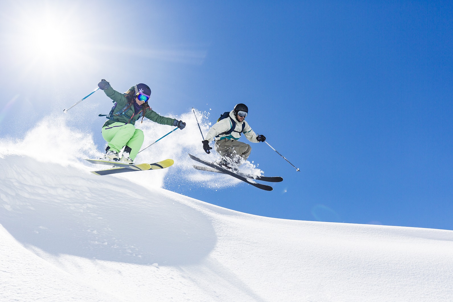Woman and man skiing and jumping