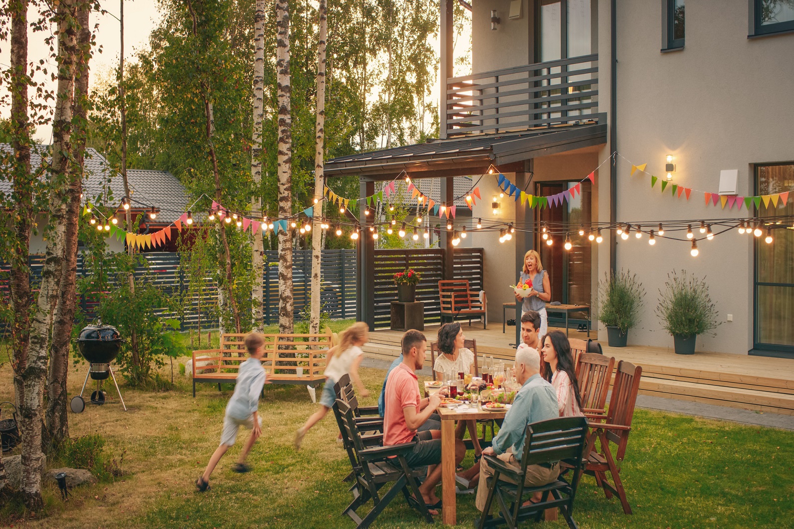 family celebrating in backyard eating dinner after getting homeowner's insurance